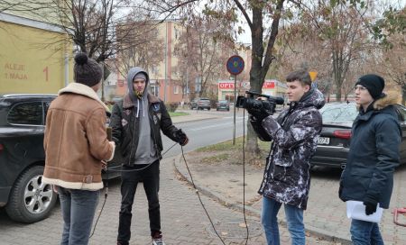 czwórka chłopców na chodniku z kamera i mikrofonem